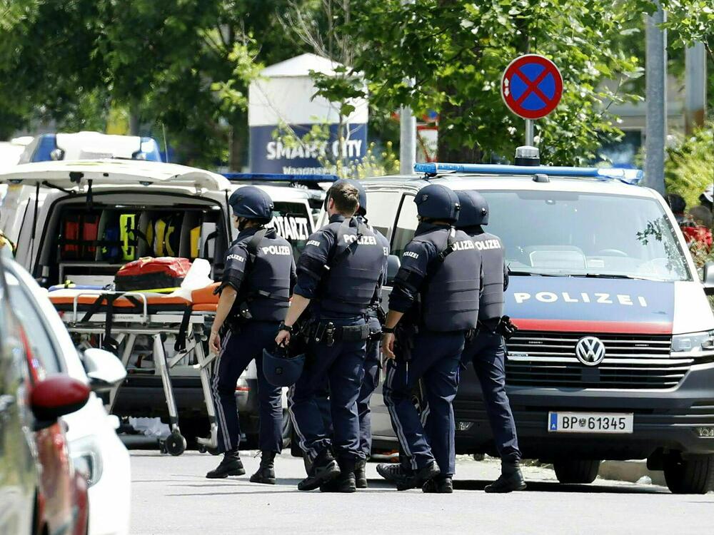 Police officers are seen in a street near a school where a gunman opened fire Tuesday morning in Graz, Austria.