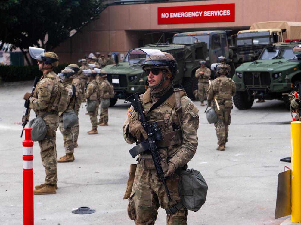 National Guard troops stand outside the Metropolitan Detention Center on Sunday in Los Angeles. Tensions in the city remain high after the Trump administration called in the National Guard against the wishes of city leaders following two days of clashes with police during a series of immigration raids.