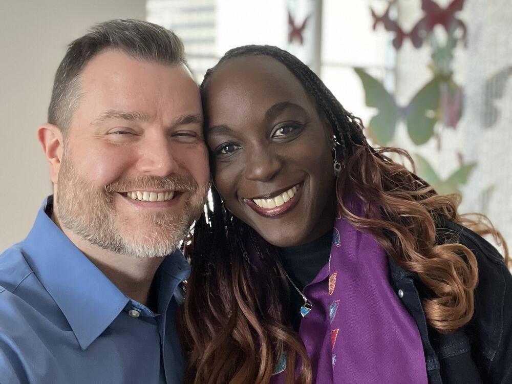 Isaiah Schauer and his wife take a selfie together, with wide smiles as they are cheek-to-cheek.