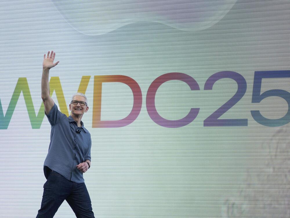 Apple CEO Tim Cook waves to attendees during an event on the Apple campus in Cupertino, Calif., Monday, June 9, 2025.