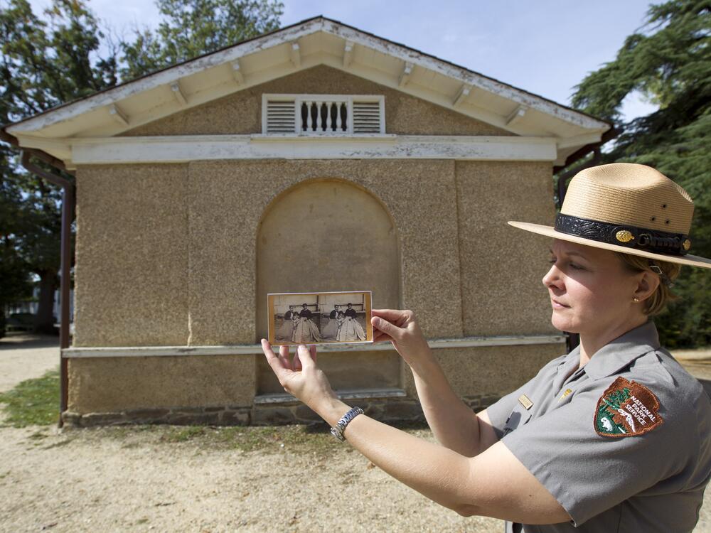 National Park Service Jennifer Mummart holds the photo of Selina Norris Gray, at the site where was taken at Arlington National Cemetery Oct. 9, 2014, in Arlington, Va. Gray was a black woman known for saving some of George Washington's heirlooms when Union soldiers seized and occupied Arlington House, the home of Confederate Army General Robert E. Lee, on May 24, 1861.