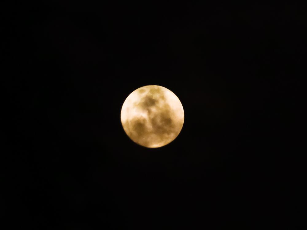 The Strawberry Moon appears behind clouds in Tangunan Village, Mojokerto, East Java Province, Indonesia.