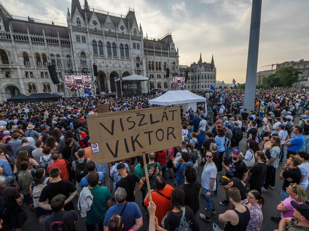 Demonstrator hokds a placard reading 