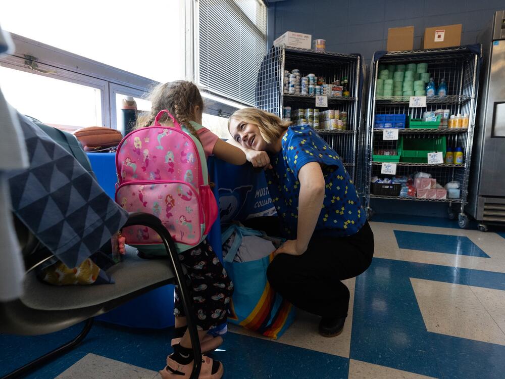 Megan Mainzer, the McKinney-Vento liaison for Middletown Public Schools in Rhode Island, speaks with a young girl at a school food and clothing pantry that's managed, in part, with federal grant money.