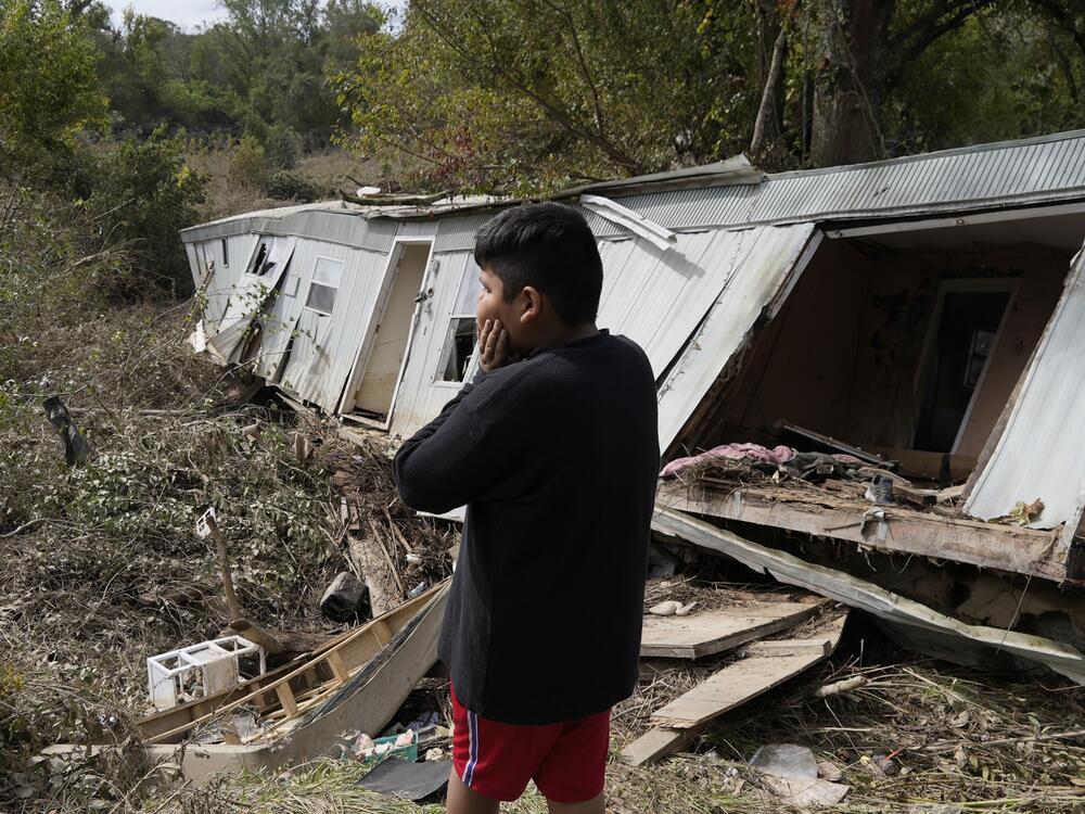 Gerardo Hernandez Juarez stares at what is left of his family's destroyed home in Hendersonville, N.C., in October 2024 in the aftermath of Hurricane Helene.