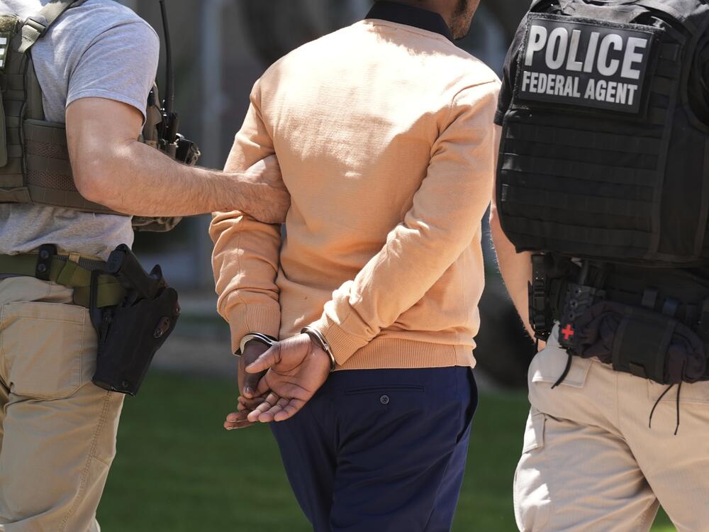 Federal agents take someone into custody after an immigration court hearing outside immigration court on May 21, 2025, in Phoenix.