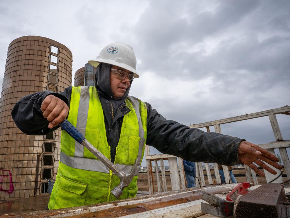 On the site of a former ranch slated for housing development on the outskirts of Aurora, Colo., Pedro Macedo of Perks Deconstruction pulls nails from a wood frame that once stood in a barn.