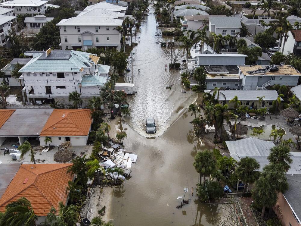 A vehicle drives on a flooded street after Hurricane Milton in Siesta Key, Fla., on Oct. 10, 2024. The monster weather system sent tornadoes spinning across the state and flooded swaths of the Tampa Bay area.