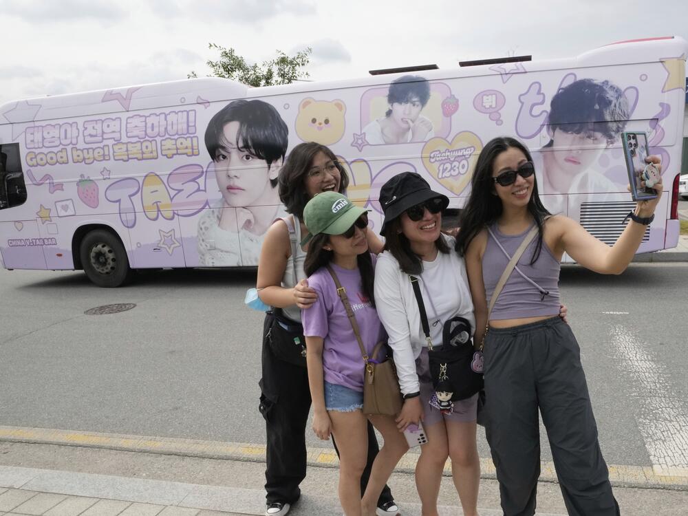 Fans take photos after K-pop band BTS members RM and V are discharged from a mandatory military service in Chuncheon, South Korea on Tuesday.
