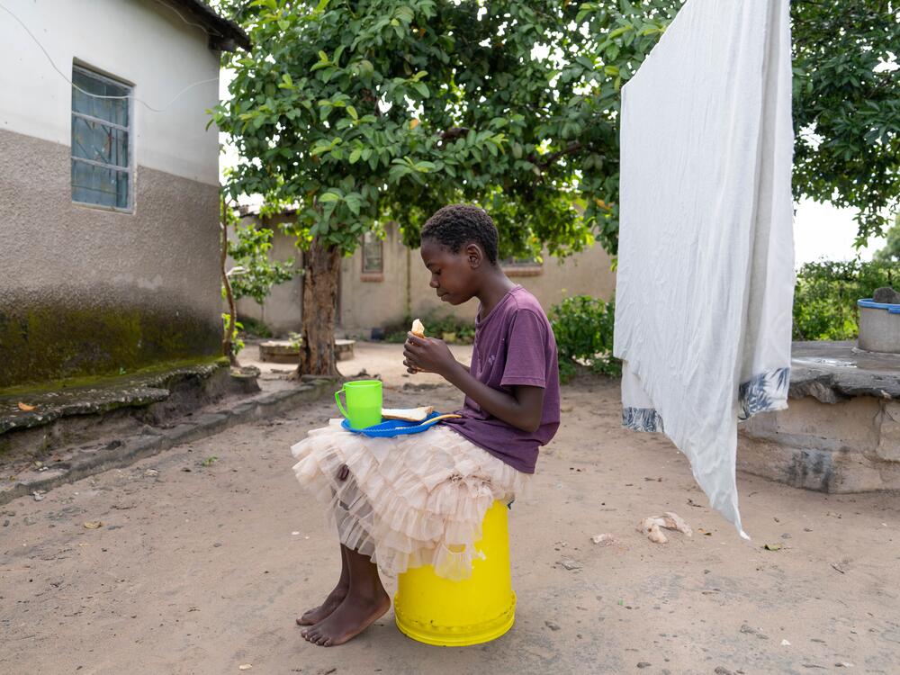 The U.S. government's PEPFAR program provided AIDS orphans with food, clothing, school fees — and medicine if they were HIV-positive, like Diana. Now, without aid, Diana and the family she lives with are scrambling to provide these necessities. Here, Diana eats breakfast before heading to school.
