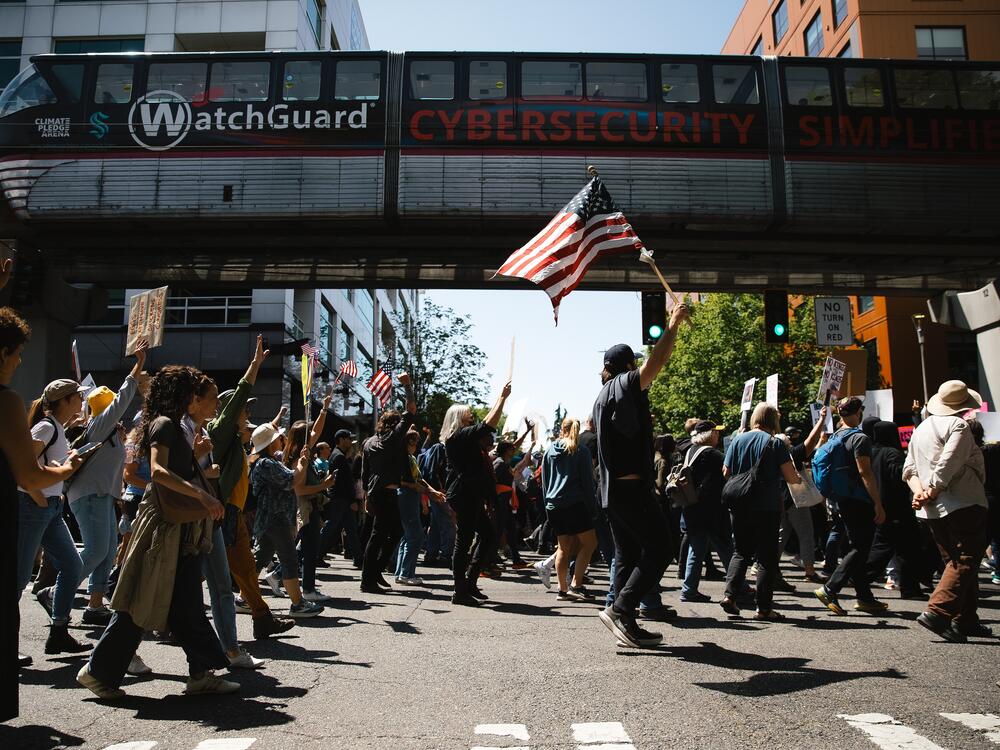 Seattle: Demonstrators cheer after getting a horn from the Seattle Monorail while marching from Cal Anderson Park to Seattle Center.