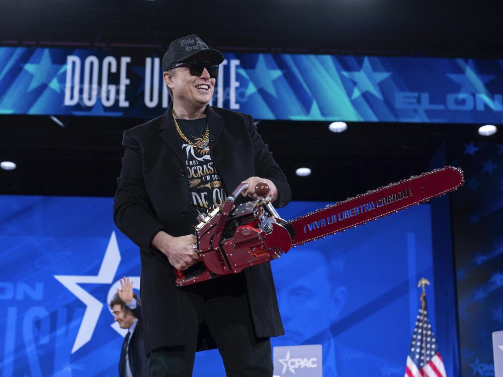Elon Musk hold a chainsaw as he arrives to speak at the Conservative Political Action Conference on Feb. 20, 2025. Musk was the most visible proponent and de facto leader of the DOGE effort in the early months of the Trump administration.