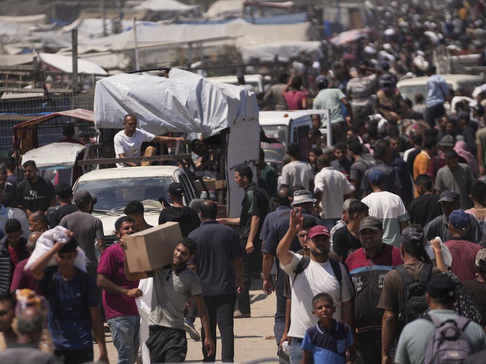 Palestinians carry bags containing food and humanitarian aid packages delivered by the Gaza Humanitarian Foundation, a U.S.-backed organization, in Rafah, southern Gaza Strip, Sunday, June 15, 2025.
