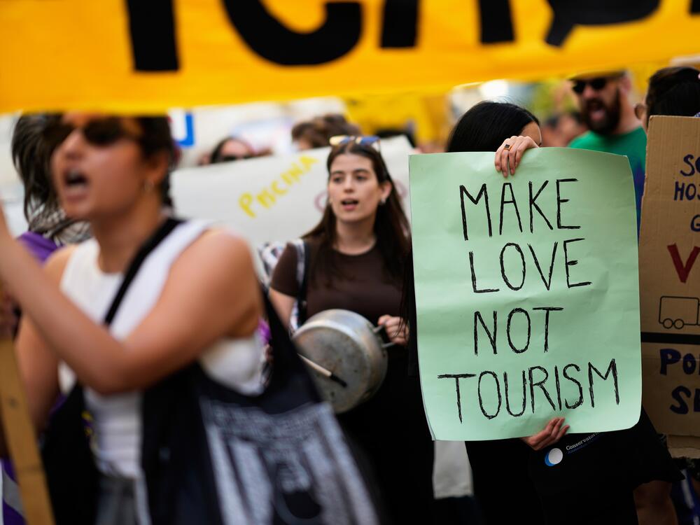 Demonstrators bang pots and shout slogans during a protest against mass tourism in Lisbon on Sunday.