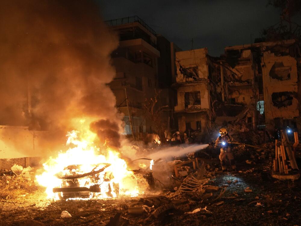 Firefighters work to extinguish a blaze after a missile launched from Iran struck Tel Aviv, Israel, on Monday.