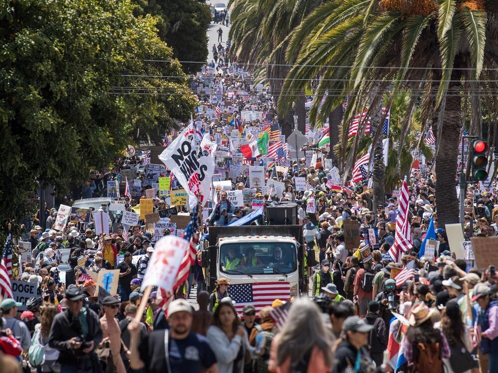 Demonstrators hold signs as they march down Dolores street protesting the Trump administration during the No Kings rally in San Francisco on Saturday.