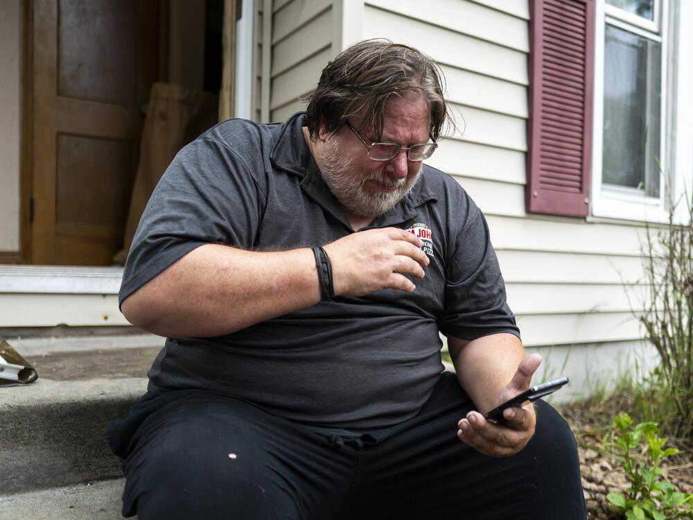 David Carlson reads a text message he received, outside his home on Saturday in Minneapolis. Carlson received a message from Vance Boelter, Carlson's roommate and a suspect in the shooting of two Democratic-Farmer-Labor lawmakers.