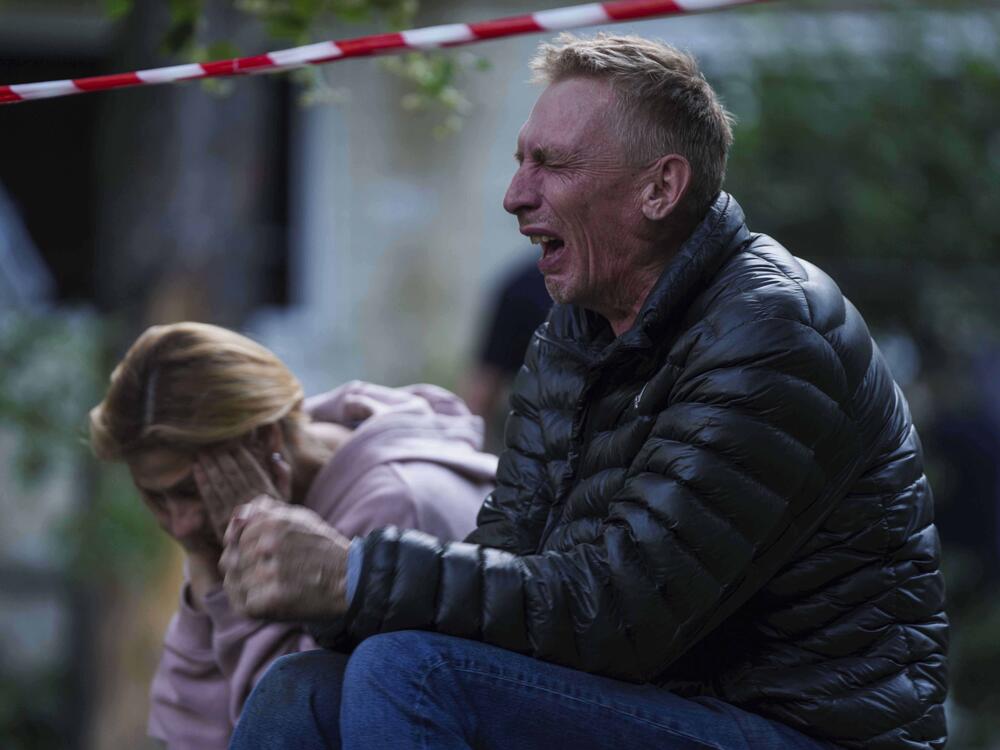 A father cries as his son is under the rubble of a multi-story residential house destroyed by a Russian strike in Kyiv, Ukraine, on Tuesday.