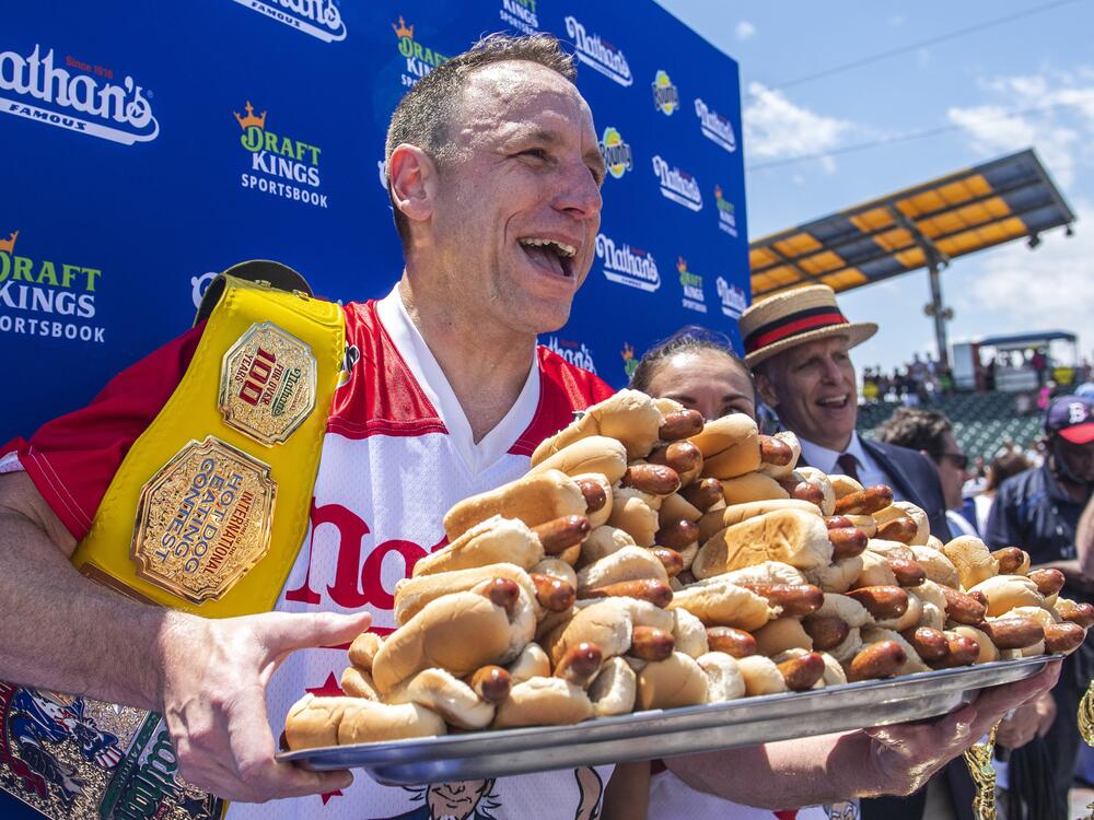 Sixteen-time champion Joey Chestnut poses after his 2021 Nathan's Famous Fourth of July International Hot Dog-Eating Contest victory on Coney Island. He returns to the stage this summer after being banned last year.