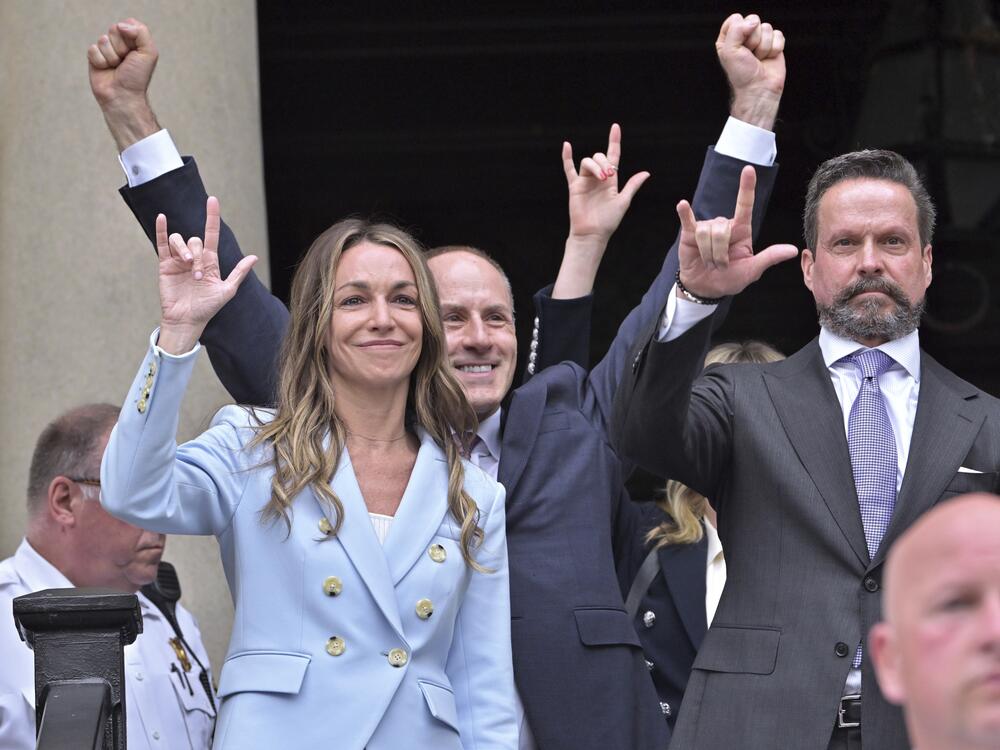 Karen Read and members of her legal team gesture to supporters with the American Sign Language 