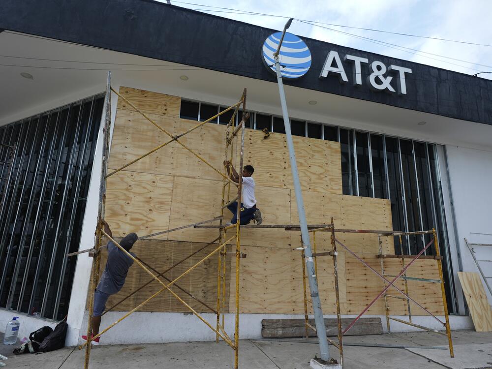 Workers board up a storefront as they prepare for the arrival of Hurricane Erick, in Acapulco, Mexico on Wednesday.
