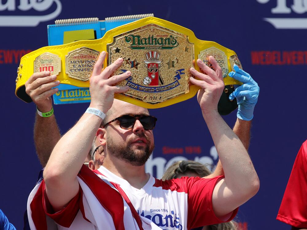 Patrick Bertoletti celebrates winning the men's title with a score of 58 during the 2024 Nathan's Famous Fourth of July hot dog eating competition.