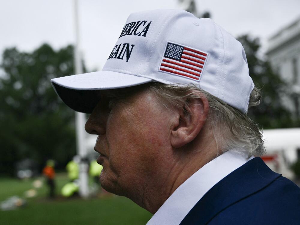President Trump speaks to the press as workers install a large flag pole on the South Lawn of the White House in Washington, DC on June 18, 2025.