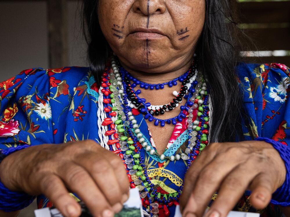 Traditional midwife Rogelina Arce Campo takes part in a newly created ritual to cope with the armed conflict in their part of Colombia. She tore an image of a place that has suffered from the violence, then used herbs and sutures to symbolically heal it.