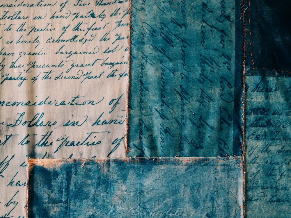 The Baker Family land deed from 1879 was made into a cyanotype and stitched together using fabric from <a href=