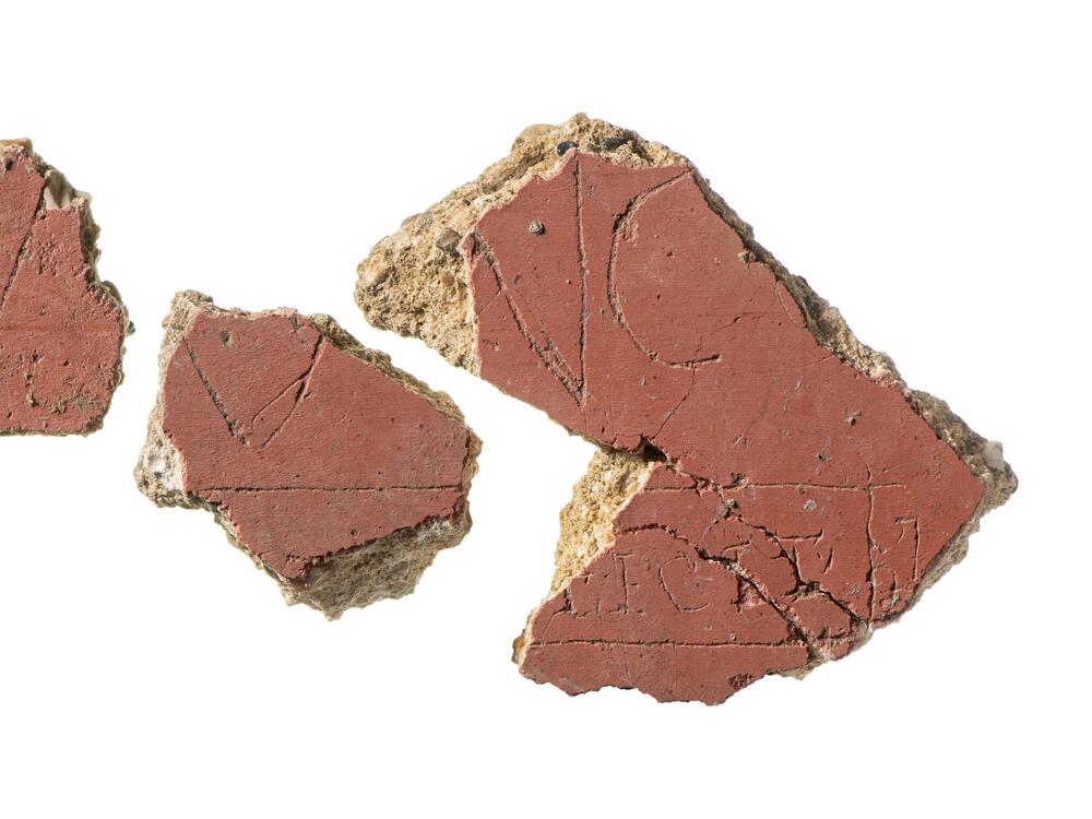 Framed by a <em>tabula ansata</em> — a decorative tablet that's typically used to sign artworks — an inscription includes the Latin word 'FECIT,' meaning 