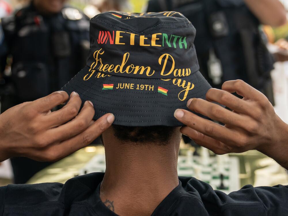 An attendee adjusts his Juneteenth-themed hat during a neighborhood Juneteenth festival on June 17, 2023, in Washington, DC.