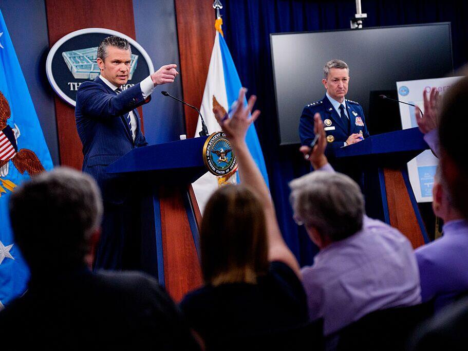 Defense Secretary Pete Hegseth (left), accompanied by Chairman of the Joint Chiefs of Staff Air Force Gen. Dan Caine, takes a question from a reporter during a news conference at the Pentagon on Sunday in Arlington, Va.