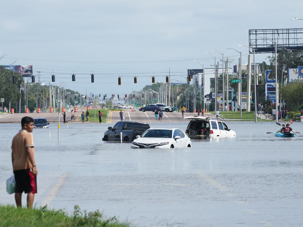 A young man looks on as cars are flooded in the water as the streets of the Southeast Seminole Heights section of Tampa due to Hurricane Milton on October 10, 2024 in Fla.