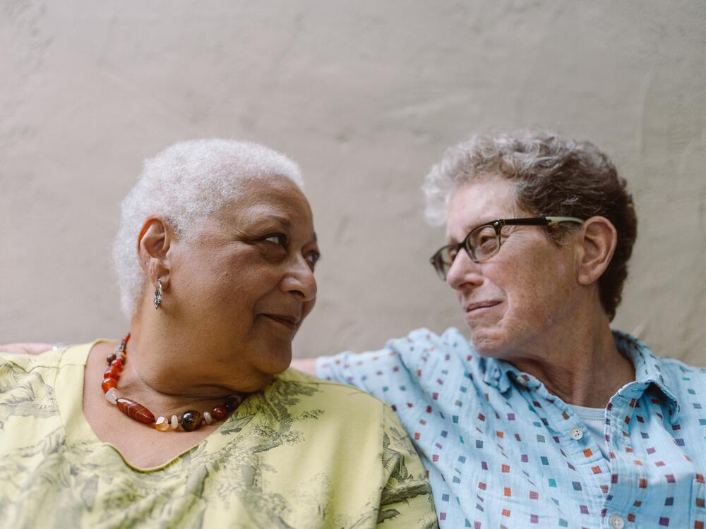 Jewelle Gomez (left) and Diane Sabin look at each other in their backyard of their home in Oakland, Calif.