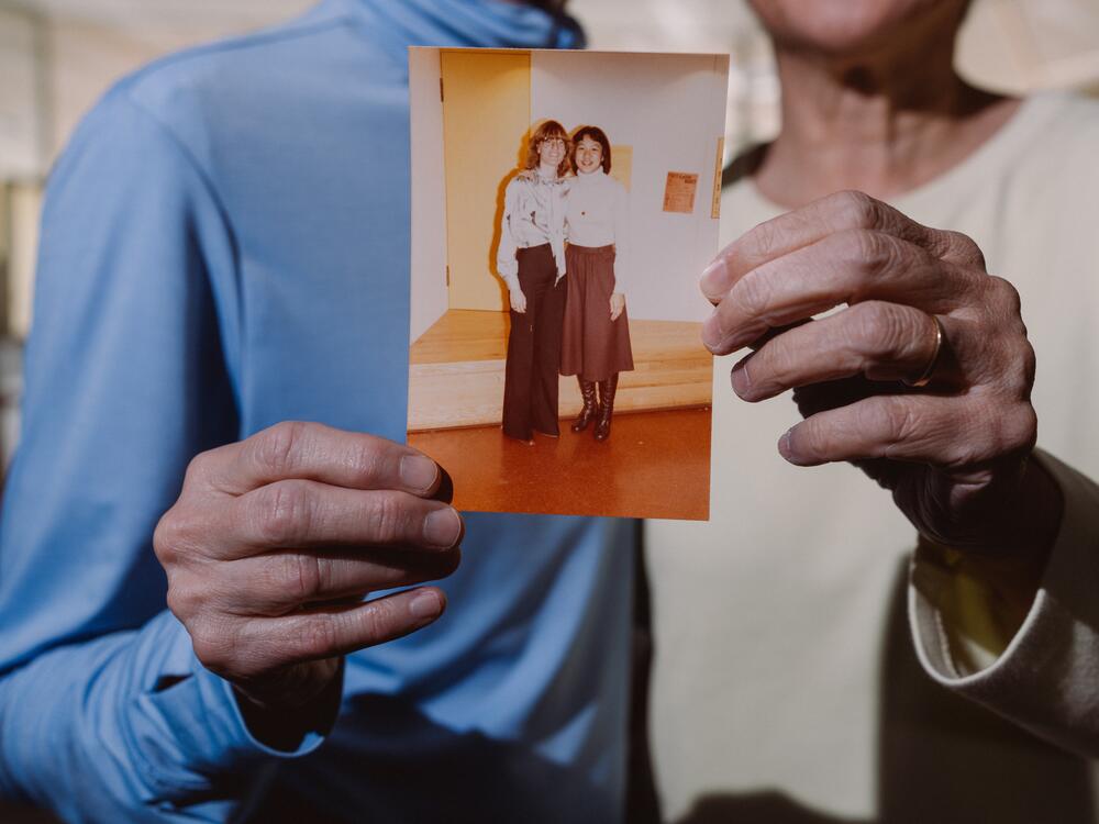 Davi and Bracha hold an old photo of them from their college years at the University of California, Berkeley.