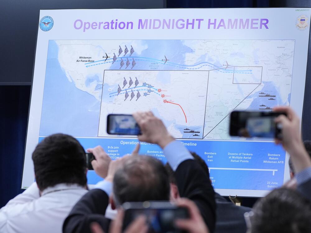 Reporters take photos of a displayed graphic as Defense Secretary Pete Hegseth and Joint Chiefs Chairman Gen. Dan Caine speak during a news conference at the Pentagon in Washington, Sunday, June 22, 2025, after the U.S. military struck three sites in Iran, directly joining Israel's effort to destroy the country's nuclear program.