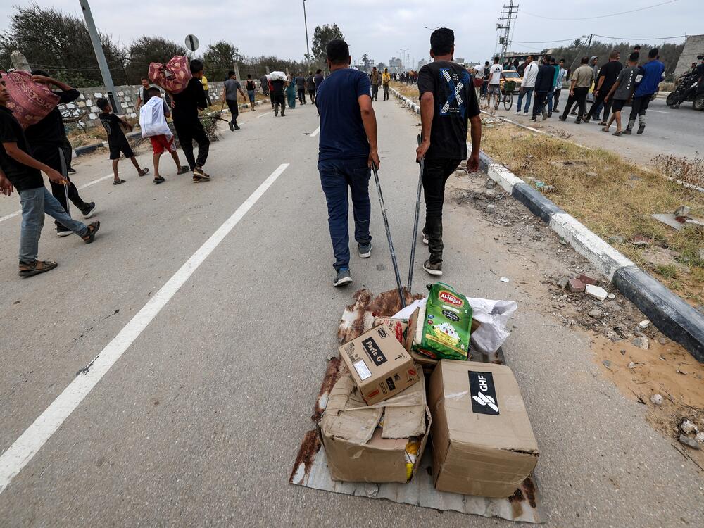 People carry relief supplies from the Gaza Humanitarian Foundation in the central Gaza Strip, on June 8.