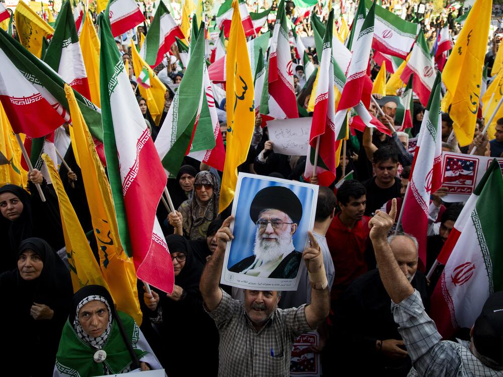 People hold flags of Iran and Hezbollah as well as posters of Supreme Leader Khamenei as Iranians take to the streets in the downtown Enghelab (Revolution) Square in Tehran, Iran on June 24, 2025, to celebrate the ceasefire after a 12-day war with Israel.