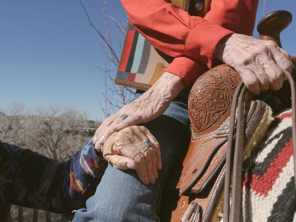Terry sits on her horse while holding Helen's hand in the backyard of their home in Santa Fe, N.M.