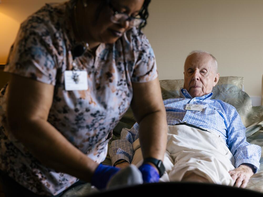 Jackline Conteh, one of many African-born caregivers at the Goodwin House Alexandria nursing home, cares for the Rev. Donald Goodness, 92. Nursing homes are subject to Immigration and Customs Enforcement raids under the Trump administration.