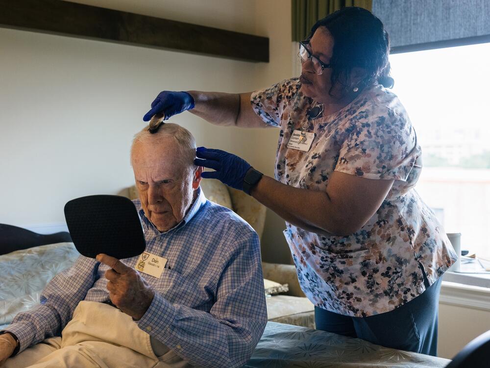 Jackline Conteh helps Donald Goodness with his hair and other 