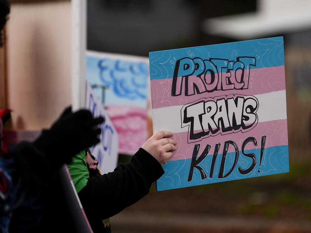 A person holds a sign during a pro-transgender rights protest outside of Seattle Children's Hospital after the institution postponed some gender-affirming surgeries for minors following an executive order by President Donald Trump, Sunday, Feb. 9, 2025, in Seattle.