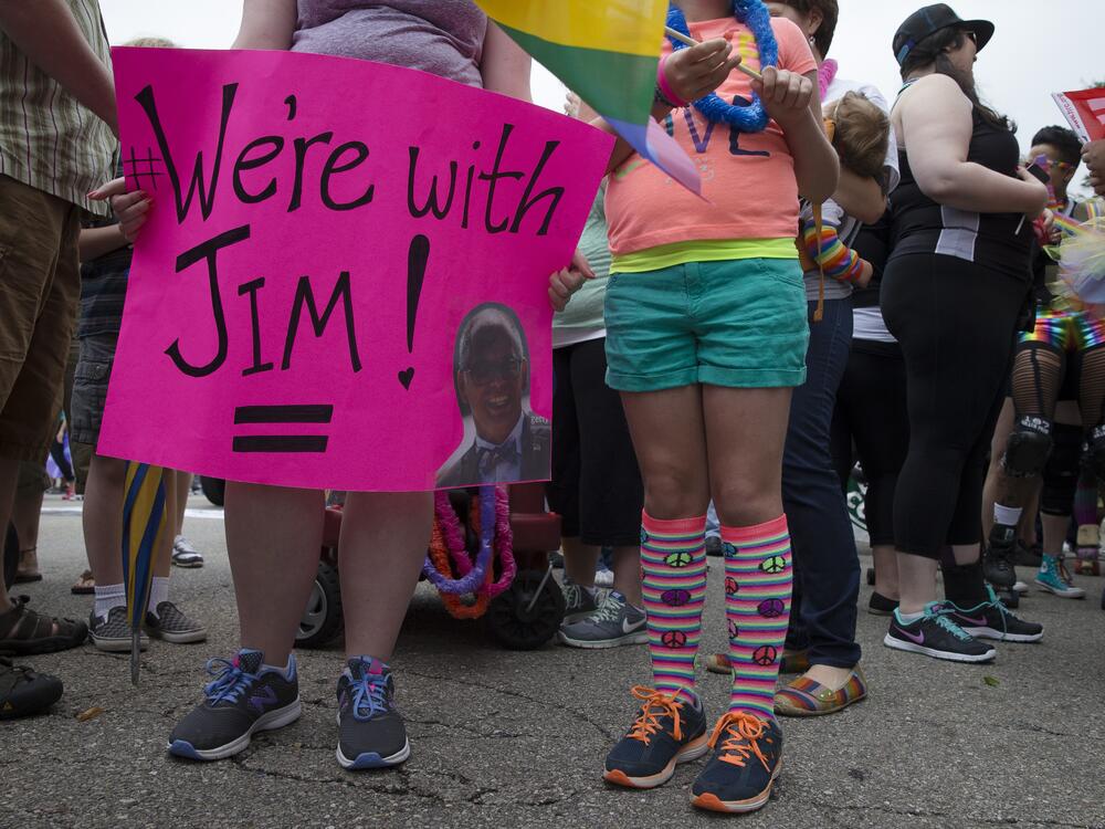A reveler holds a sign in support of gay marriage plaintiff Jim Obergefell during the Cincinnati Pride parade, Saturday, June 27, 2015.