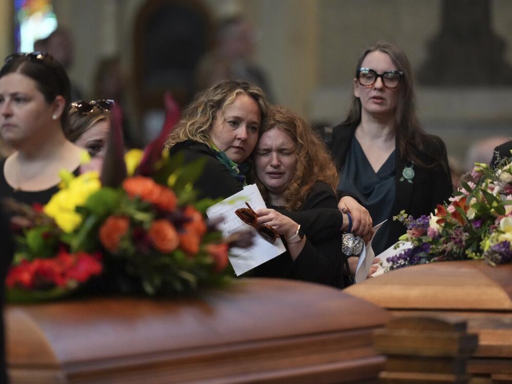 Mourners view the caskets of Melissa and Mark Horman as they enter the Basilica of St. Mary in Minneapolis before their funeral service on Saturday.
