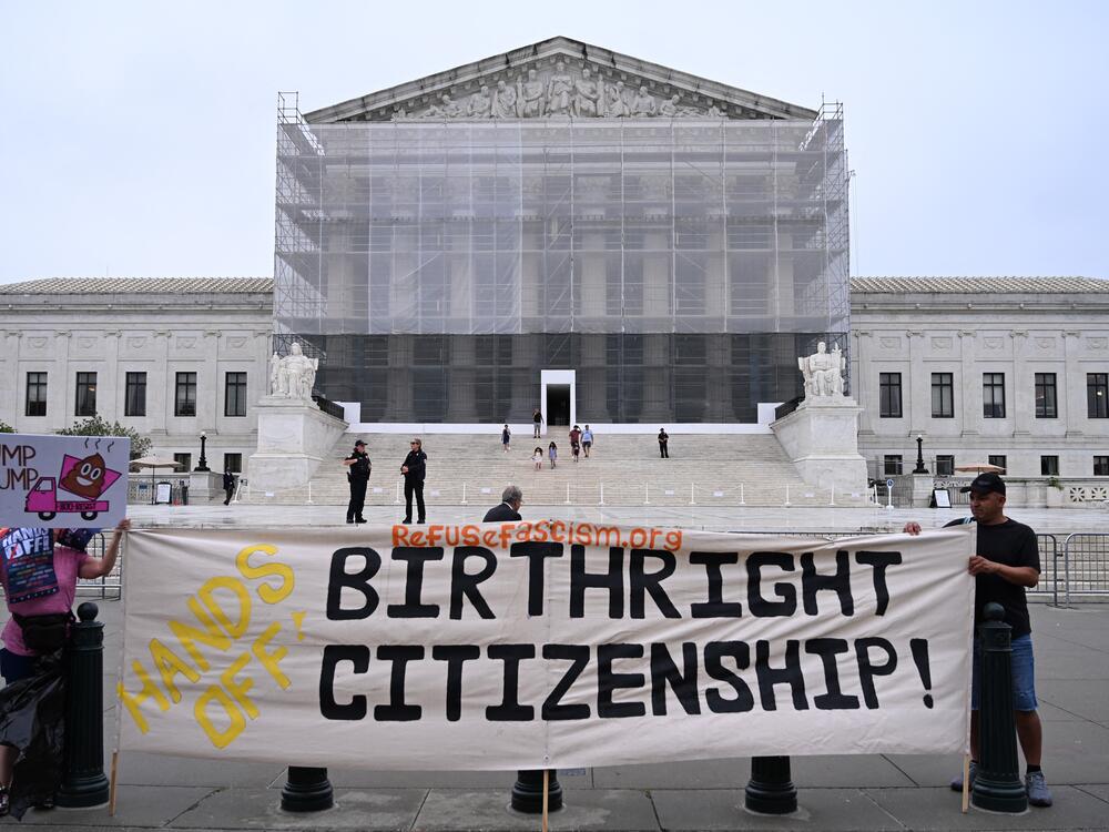 Demonstrators hold a sign reading 