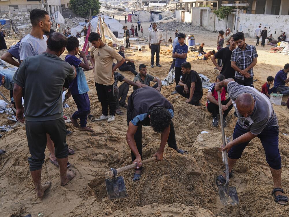 Palestinians dig through sand looking for belongings after an Israeli strike hit a displacement tent camp in Gaza City, Saturday.