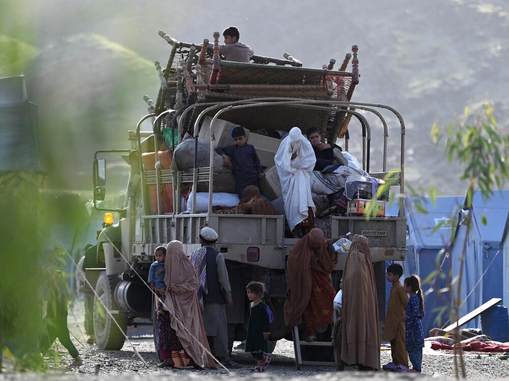 Afghan refugees climb down from a truck after arriving from Pakistan near the Torkham border with Afghanistan. Pakistan has launched a campaign to evict hundreds of thousands of Afghans who have had their residence permits canceled, including some who were born in Pakistan or lived there for decades.
