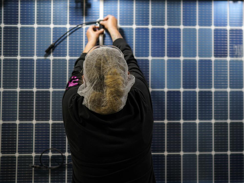An employee works on a solar panel inside a Qcells factory in Dalton, Ga.