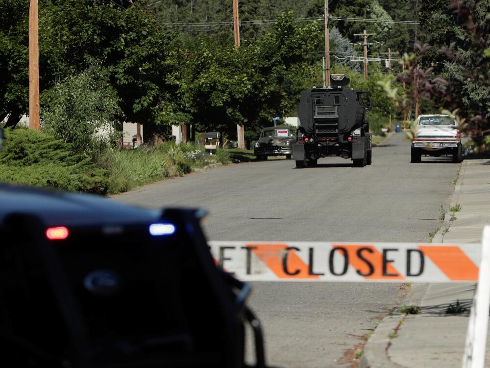 An armored police vehicle travels towards an area where multiple firefighters were attacked when responding to a fire in the Canfield Mountain area on the outskirts of Coeur d'Alene, Idaho, on Sunday.