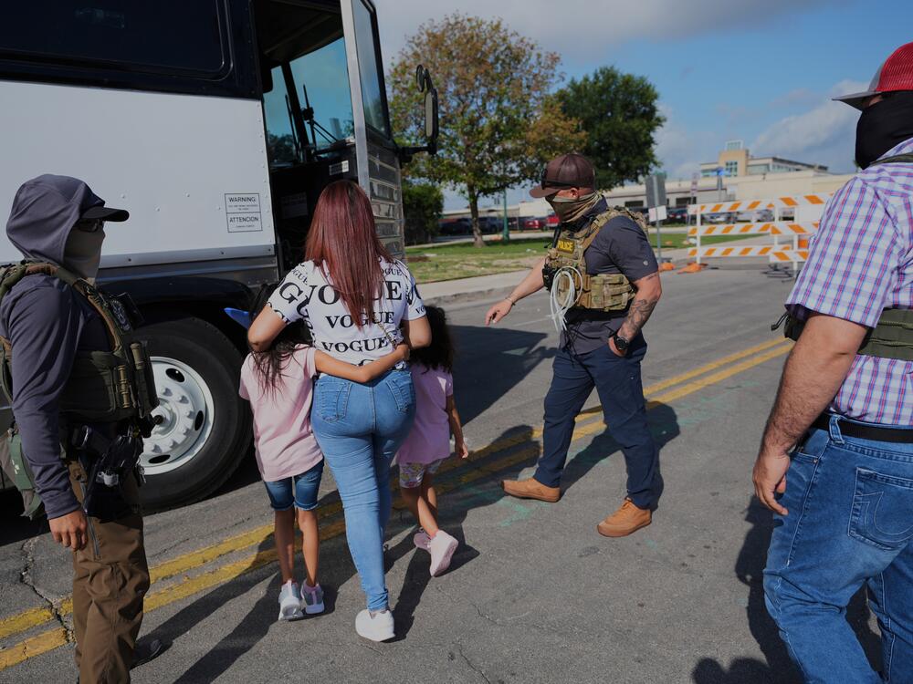 A woman from Peru and her children are detained and escorted to a bus by federal agents following an appearance at immigration court on June 23 in San Antonio.